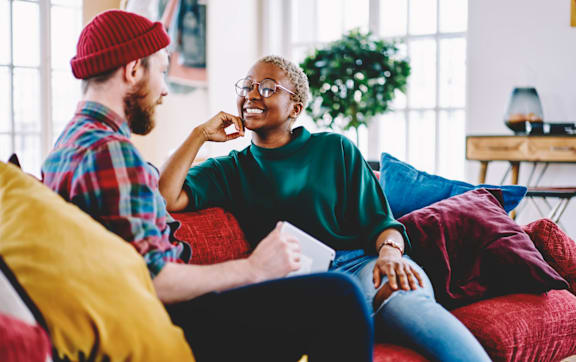 Man and Woman Sitting on Red Couch and Having a Conversation