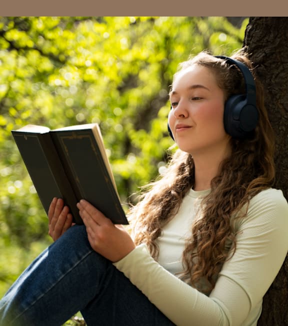 A person with headphones reading a book.