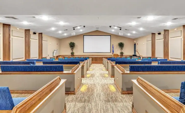 Spacious auditorium with comfortable seating and a large screen at Lakeview Retirement Community, offering various amenities for Independent Living.