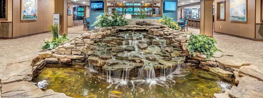 Tranquil waterfall and pond in the lobby of Lakeview Retirement Community, an Independent Living facility. The calming water feature creates a welcoming atmosphere.