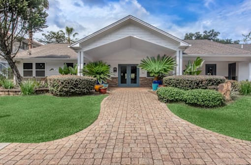 A house with a brick pathway leading to the front door.
