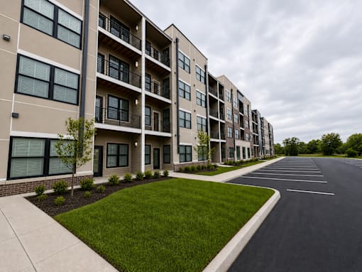 A long building with a parking lot in front.