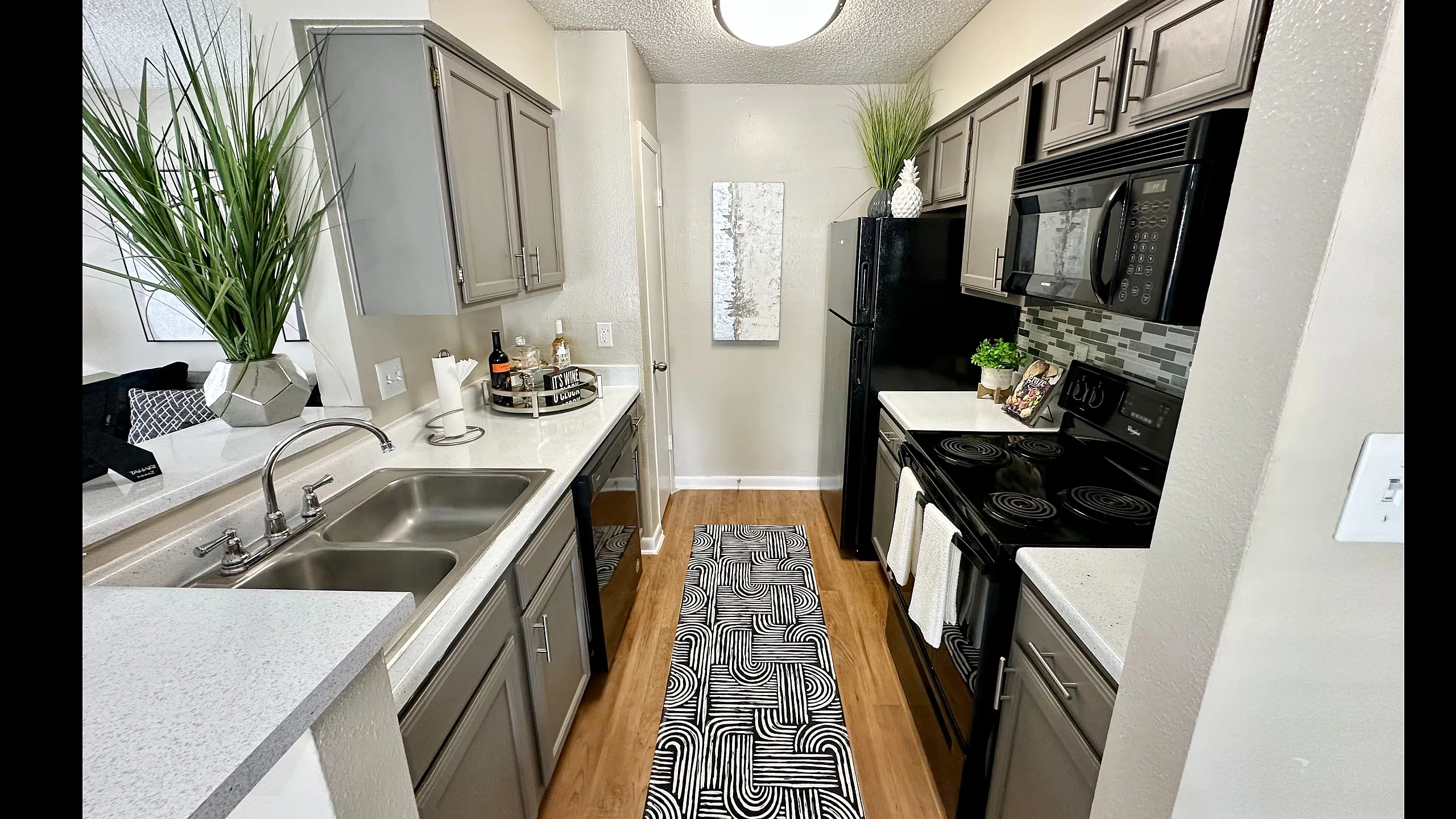Modern kitchen with sleek gray cabinetry, stainless steel appliances, stylish countertop, and elegant decorative accents.