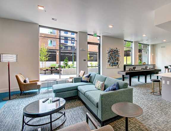 A modern living room with a kitchen area in the background. at Ravello Apartments, Redmond, WA, 98052