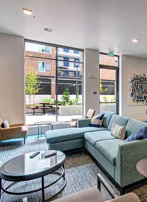 A modern living room with a kitchen area in the background. at Ravello Apartments, Redmond, WA, 98052