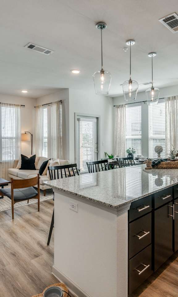 A modern kitchen with a large island and wooden floors.