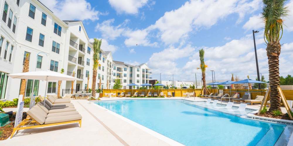 Resident holding a surfboard at Olea eTown in Jacksonville, Florida