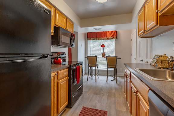 A modern kitchen with a stainless steel refrigerator and grey cabinets.
