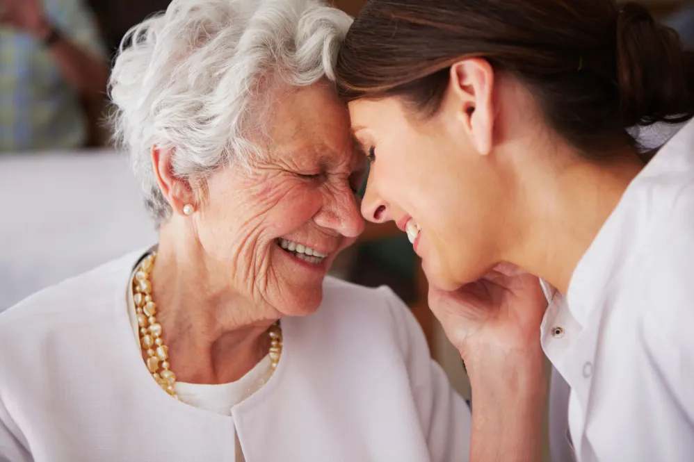 Senior mother and adult daughter embracing one another