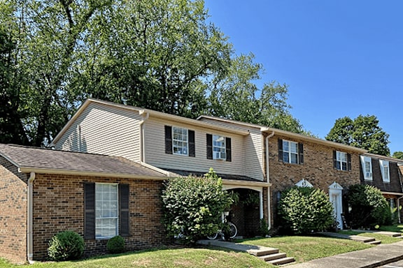 A row of houses with green trees in the background.
