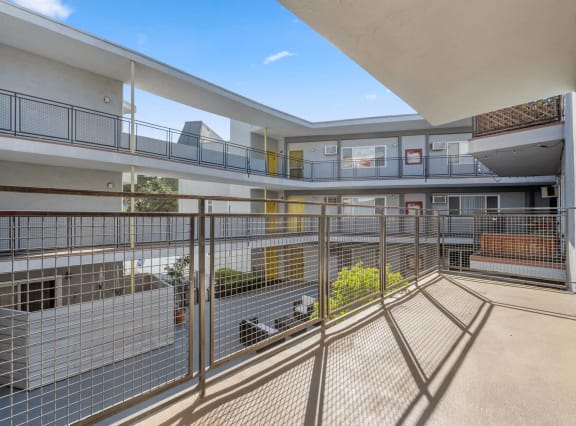 the courtyard of an apartment building with a fenced in yard