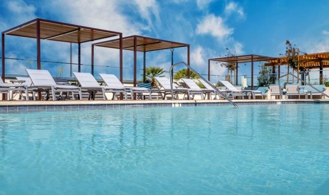 a pool with chairs and a gazebo by it