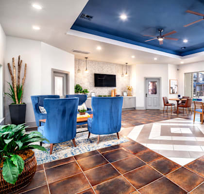 A living room with a brown floor and a ceiling fan.
