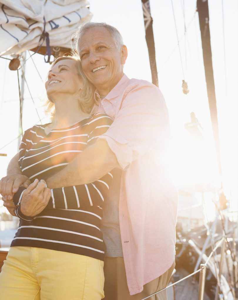 man and woman hugging on the deck of a sailboat