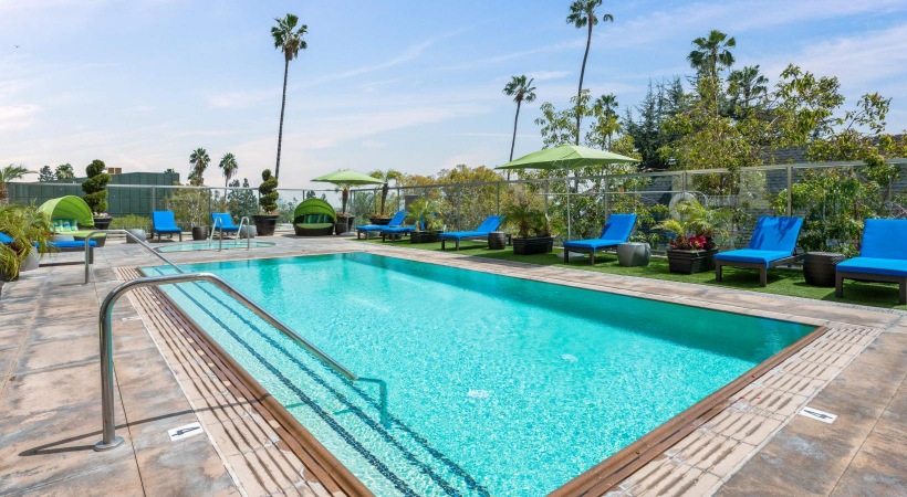 a swimming pool with chairs and umbrellas by it