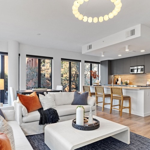 living room with large windows couches and coffee table