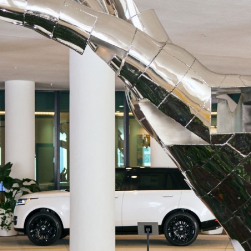 Sculpture of Hand with Vehicle in Background