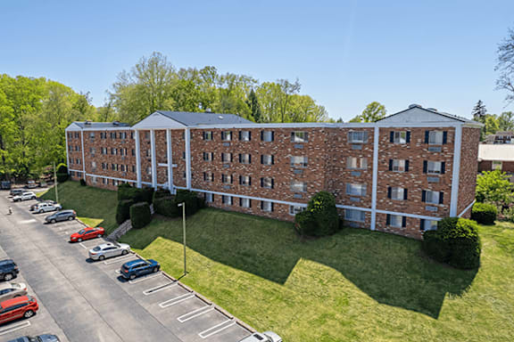 A large brick building with a parking lot in front.