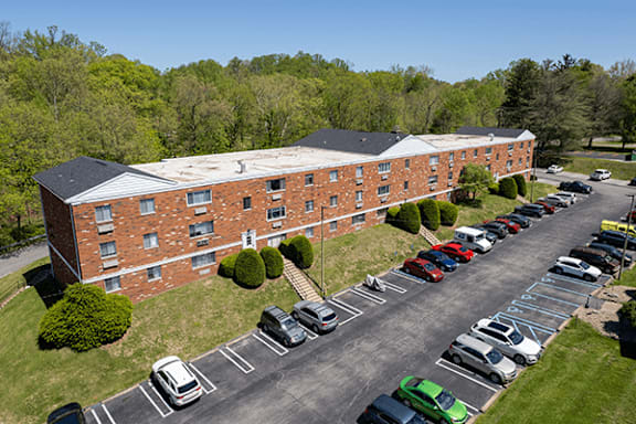 A parking lot in front of a red brick building.