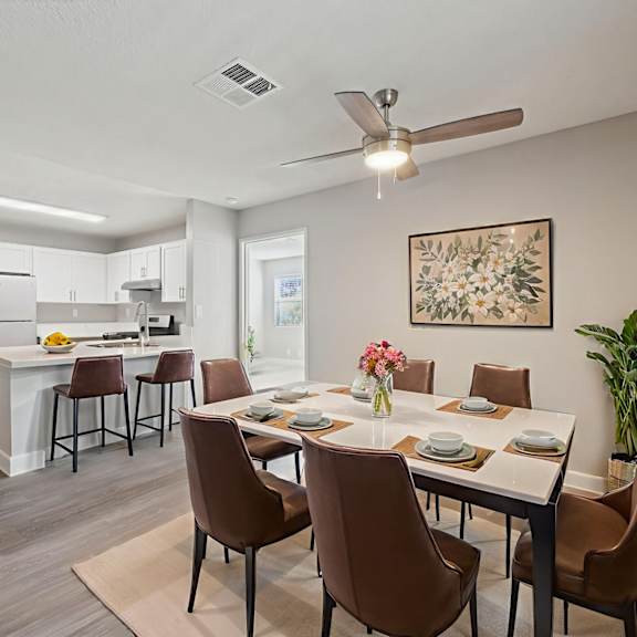 A dining room with brown chairs and a white table.