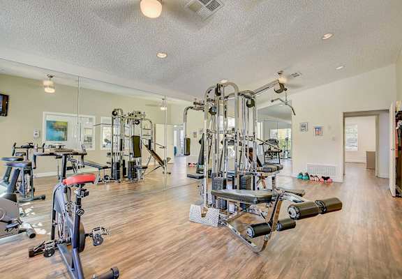 A spacious gym with a variety of equipment including treadmills, weights, and exercise machines.