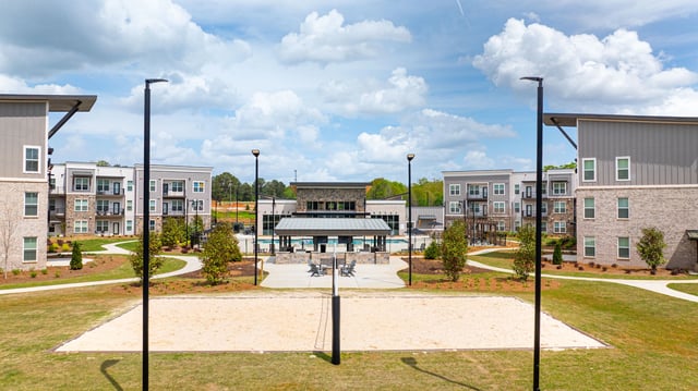 Apartment complex courtyard with pool and volleyball court. Tour 1-bedroom apartments for rent in Monroe, GA at The Jax today.