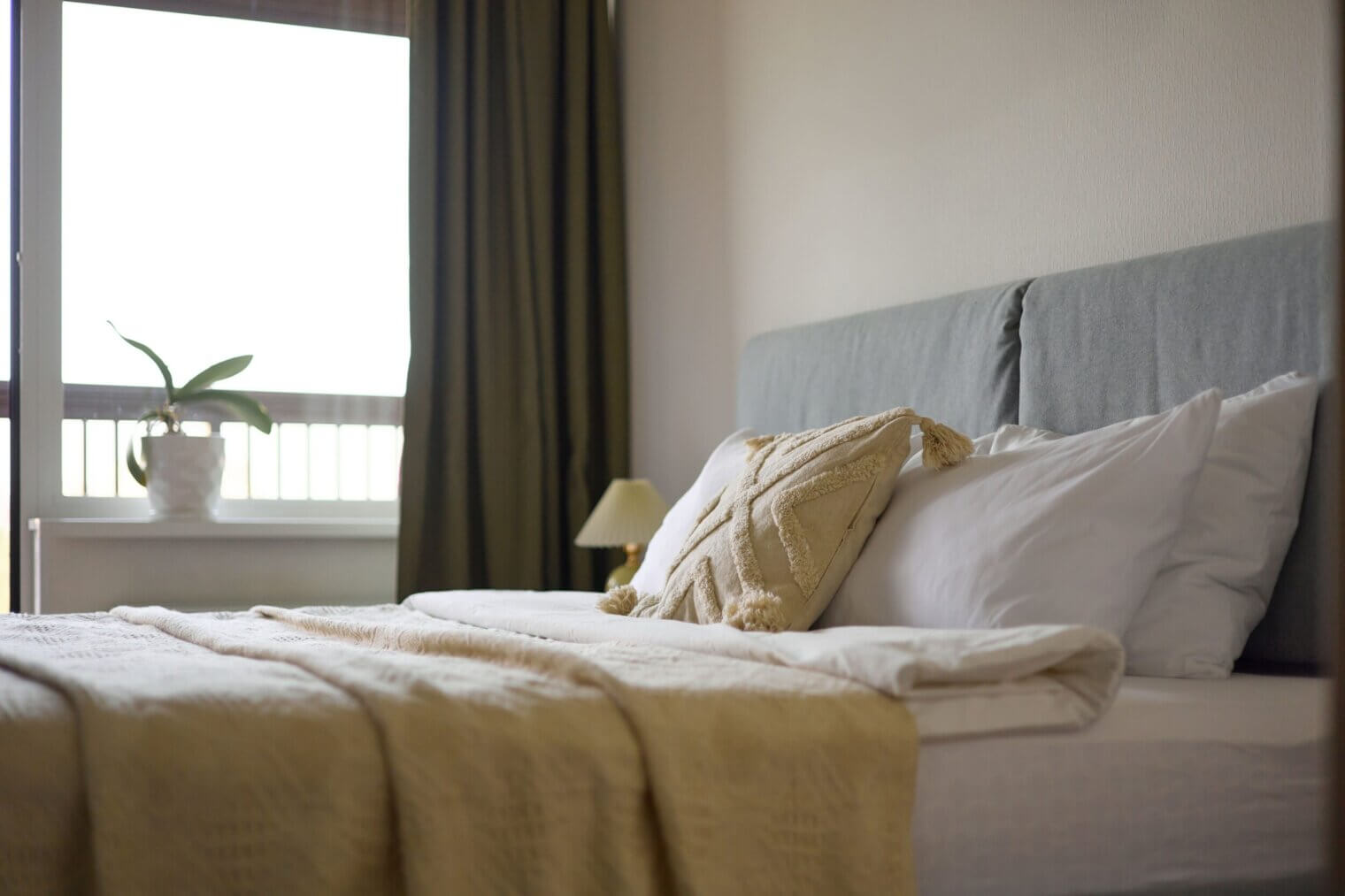 A close-up of a beautifully made bed with premium linens in a spacious bedroom at Kinward at Spencer Glen Riverview townhomes.