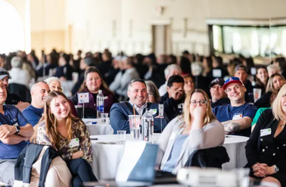 Engaging conference audience enjoying a lively presentation in a bright, spacious venue.