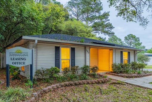A small house with a sign that says "Summer Place Leasing Office".