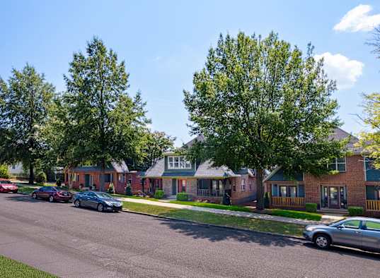 A street with cars and houses on both sides.