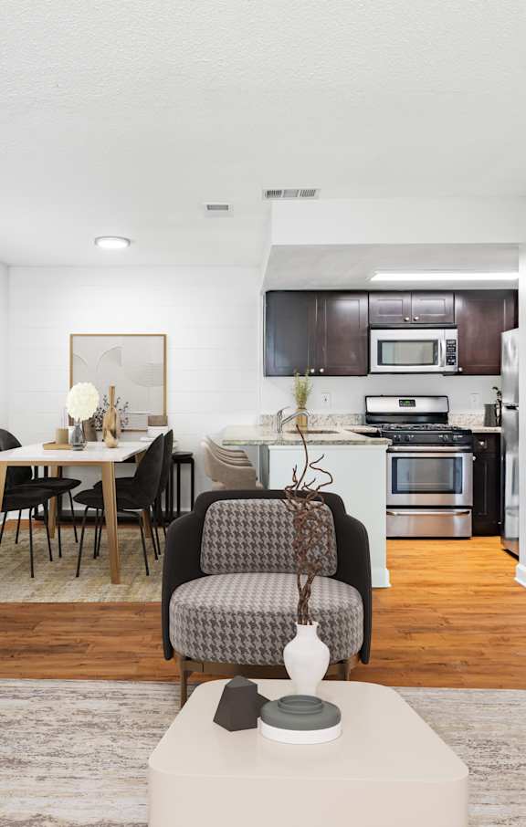 a living room and kitchen with white walls and hardwood floors