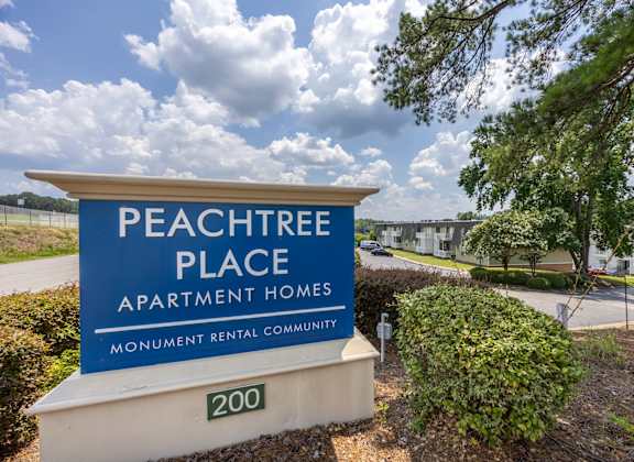A sign for Peachtree Place Apartment Homes in front of a tree. at Peachtree Place Apartments, South Carolina, 29210