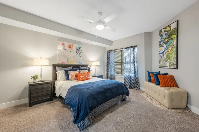 Furnished bedroom with a bed and lighted ceiling fan