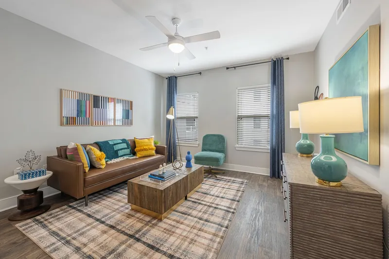 Firnished living room with lighted ceiling fan and two windows