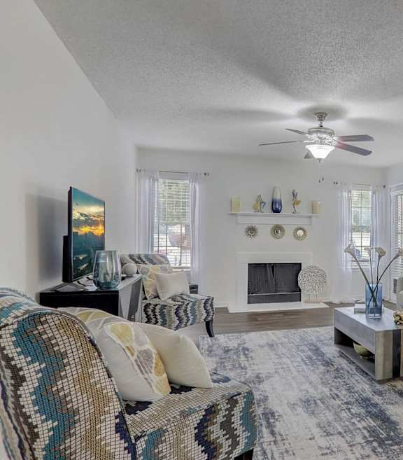 A living room with a couch, a chair, a coffee table, and a painting on the wall.