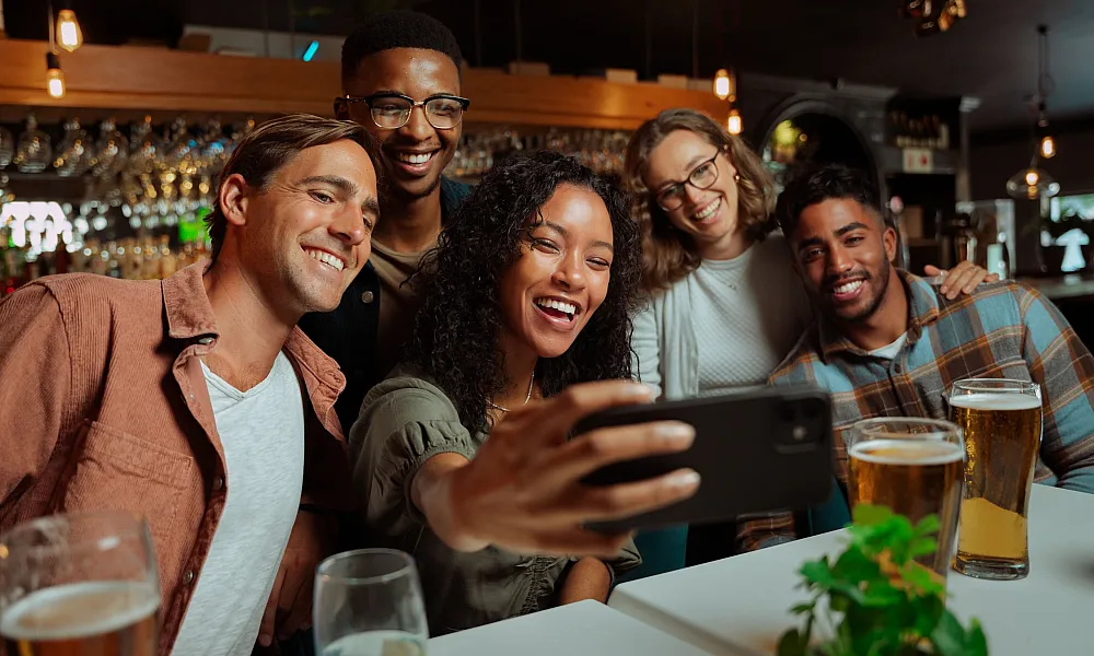 group of friends posing for a selfie at a restaurant