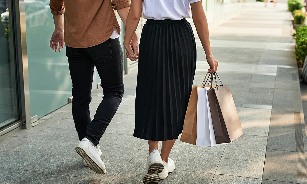 couple holding hands outdoors with shopping bags
