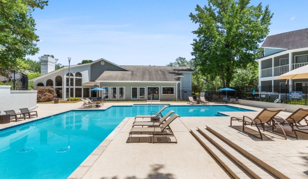 pool with trees and lounge chairs