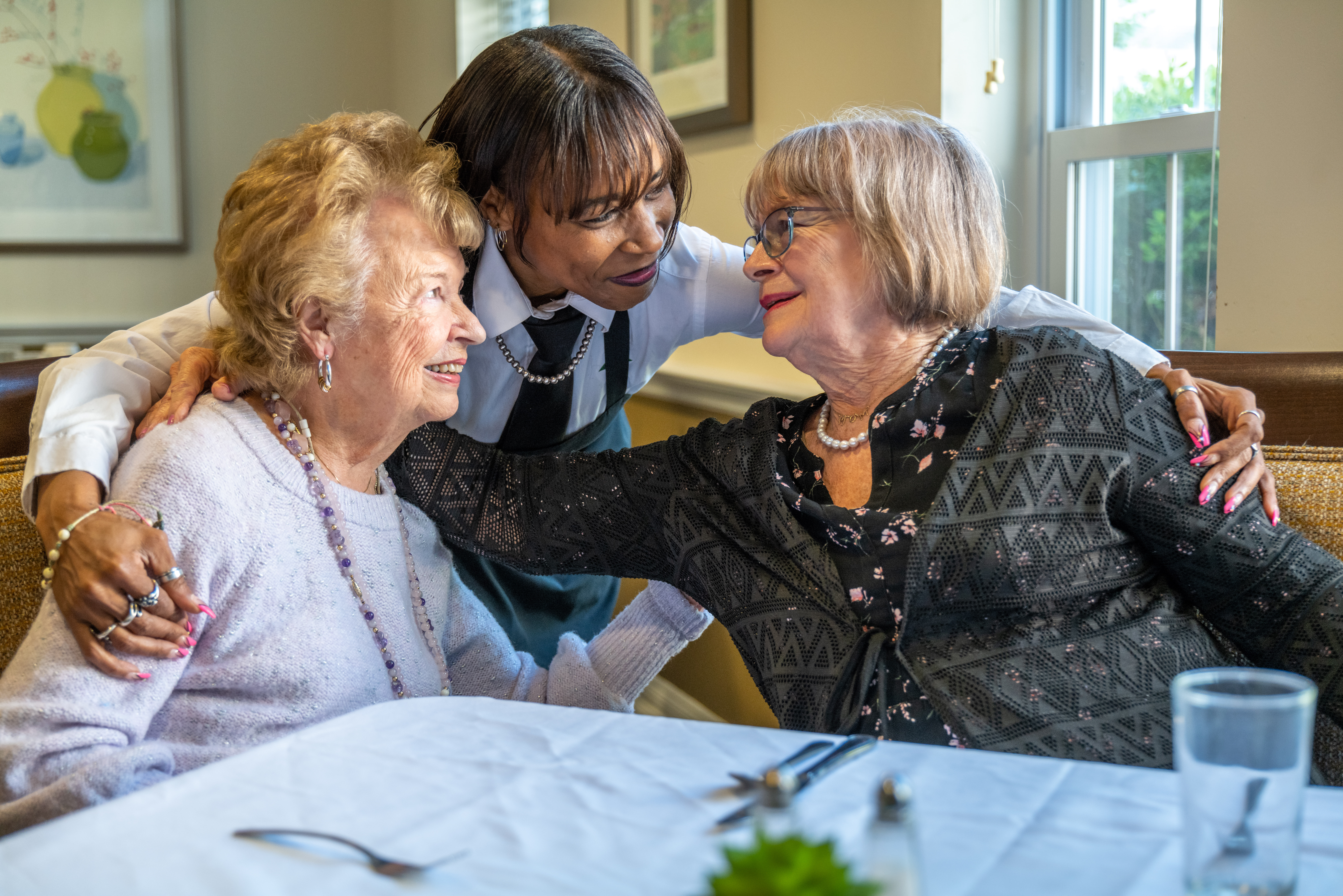 Senior living members with associate at table.