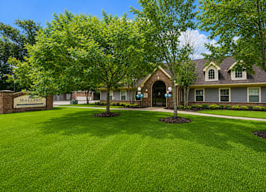 A house with a lawn and trees in front of it.