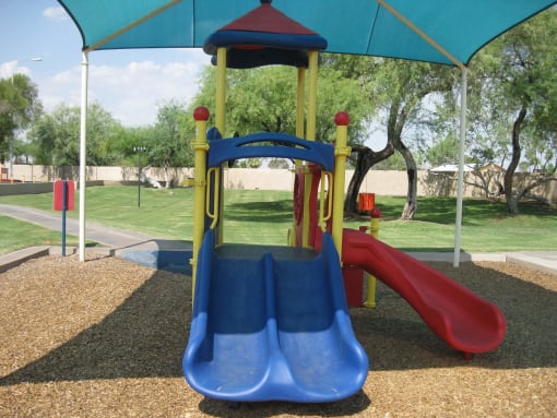 a playground with a blue slide and a red slide