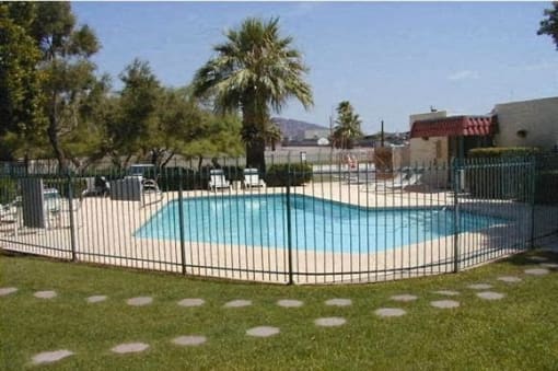 a swimming pool is behind a wrought iron fence