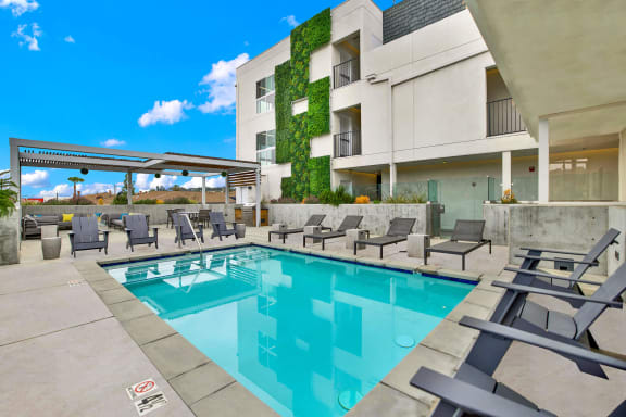 a swimming pool with lounge chairs and a building in the background at the perch, Los Angeles, CA