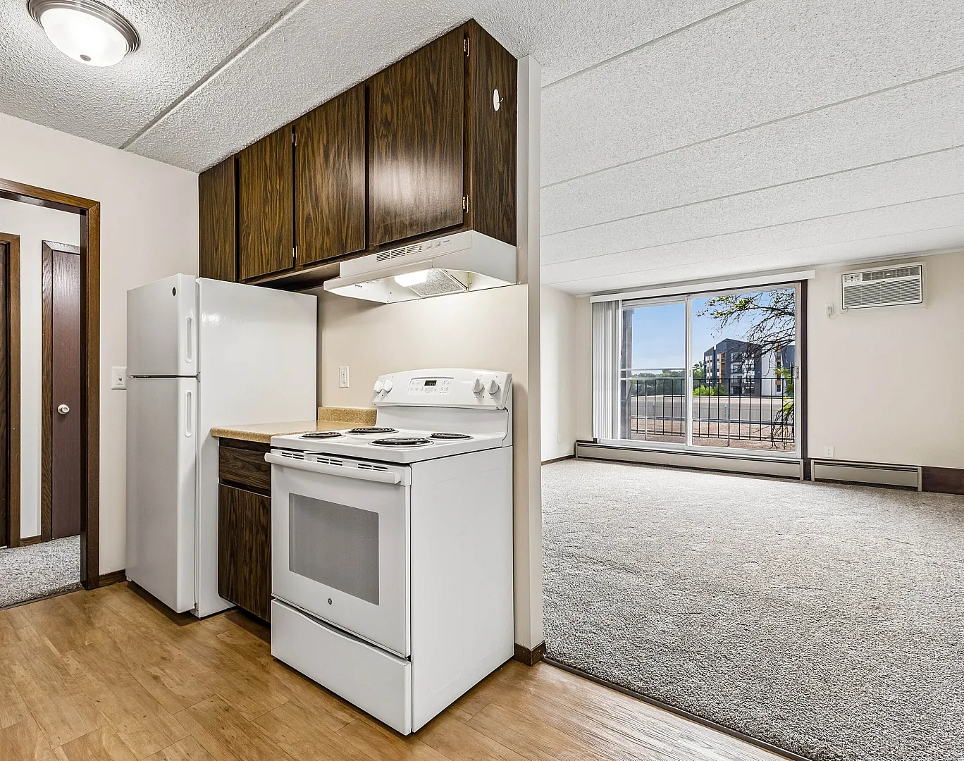 Bright and inviting apartment featuring a cozy kitchen with modern appliances, open living room with natural light, and a scenic balcony view.