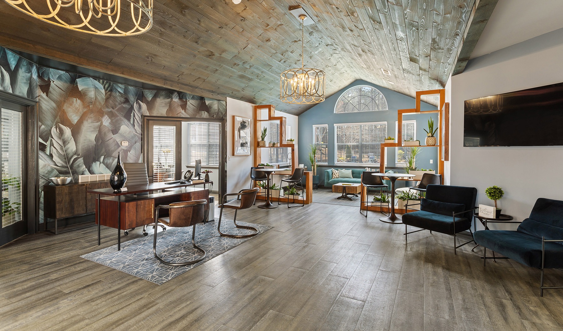 Spacious and well lit leasing office with wood floors and a large window. 