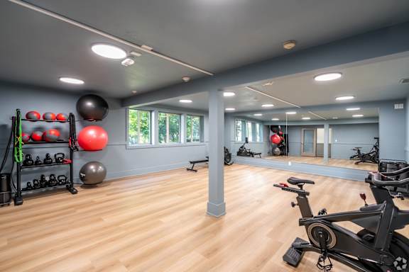 A gym with a variety of exercise equipment and a mirror on the wall.
