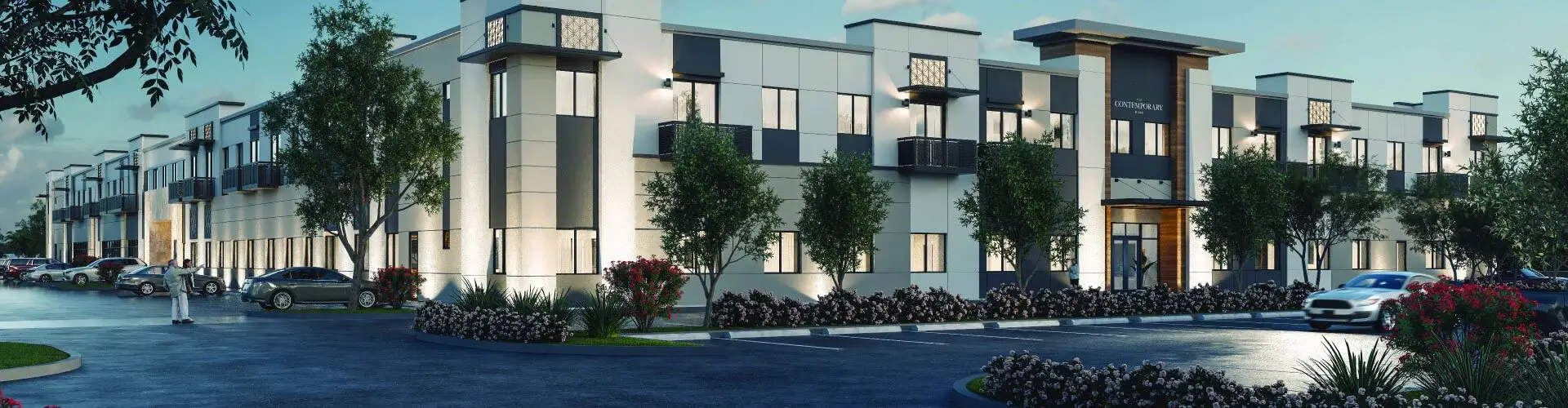 Contemporary-style senior living building with a landscaped entrance, parked cars, and people entering the facility.