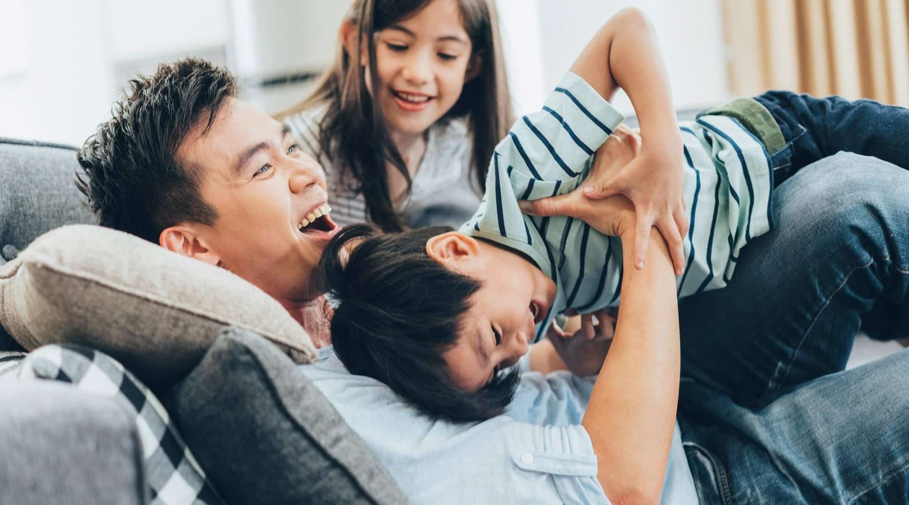 a family laughing together on a couch