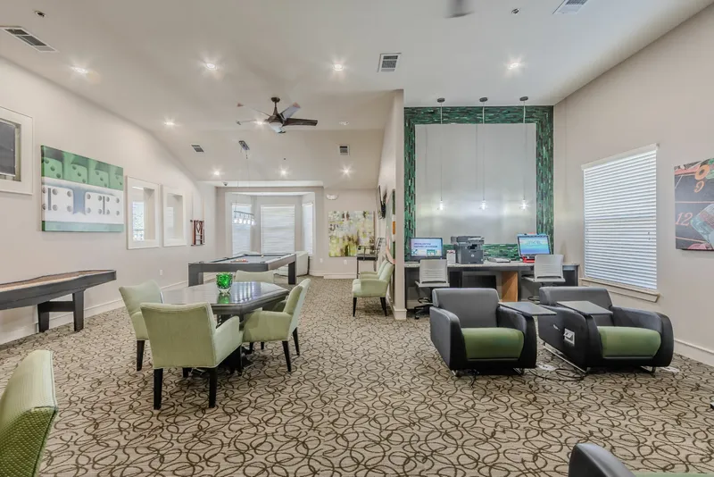 Community clubroom with game tables, lounge seating, and a business center