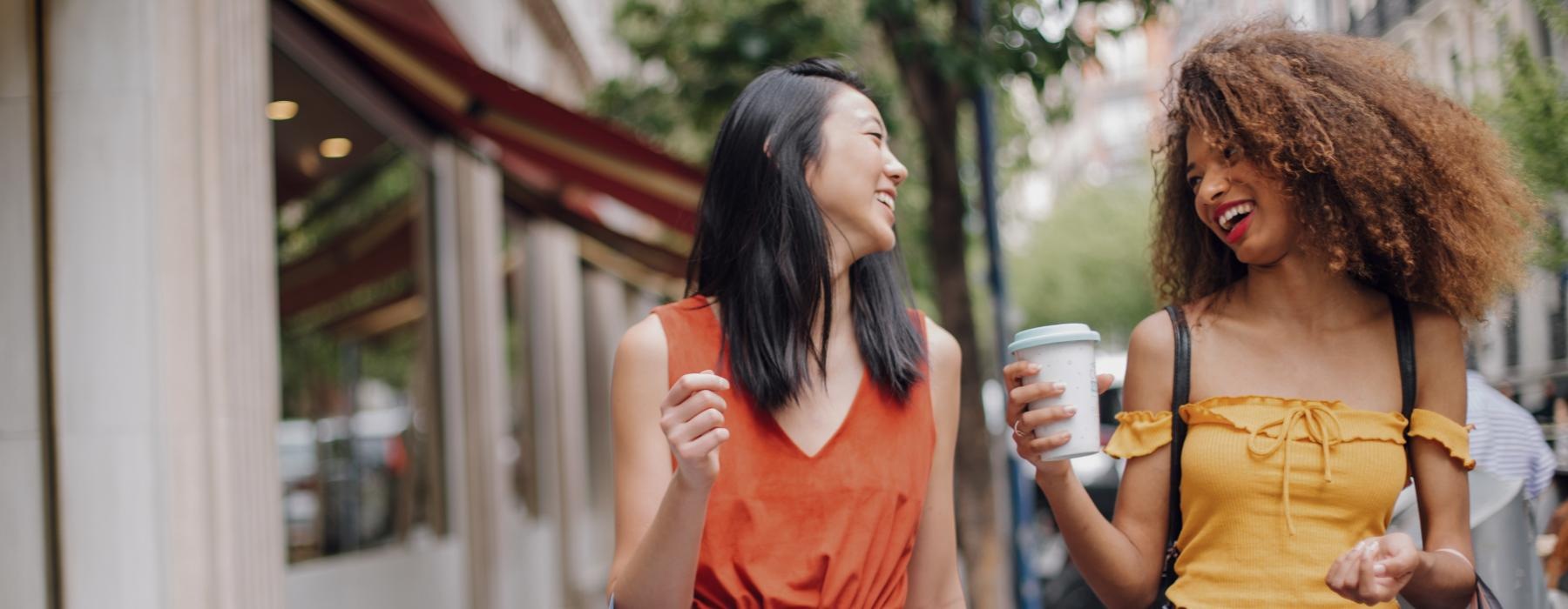 Two residents laughing and smiling with cups of coffee near Pax Place townhomes for rent in Sterling, VA.